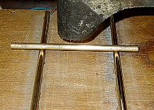 brass bar resting on two parallel brass conductors, connected to a battery and between the poles of a horseshoe magnet